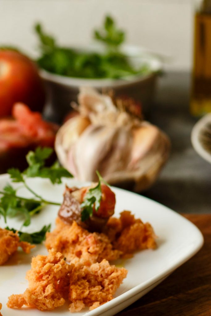 Ingredientes bizcocho de tomate salado: tomates maduros, anchoas, ajo y perejil fresco preparados para la masa