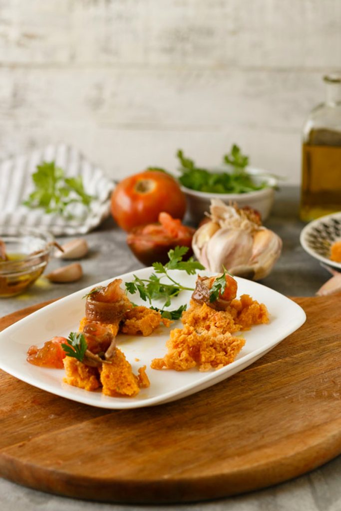 Bizcocho de tomate salado - ingredientes preparados: tomates maduros rallados, anchoas escurridas, ajo picado y perejil fresco